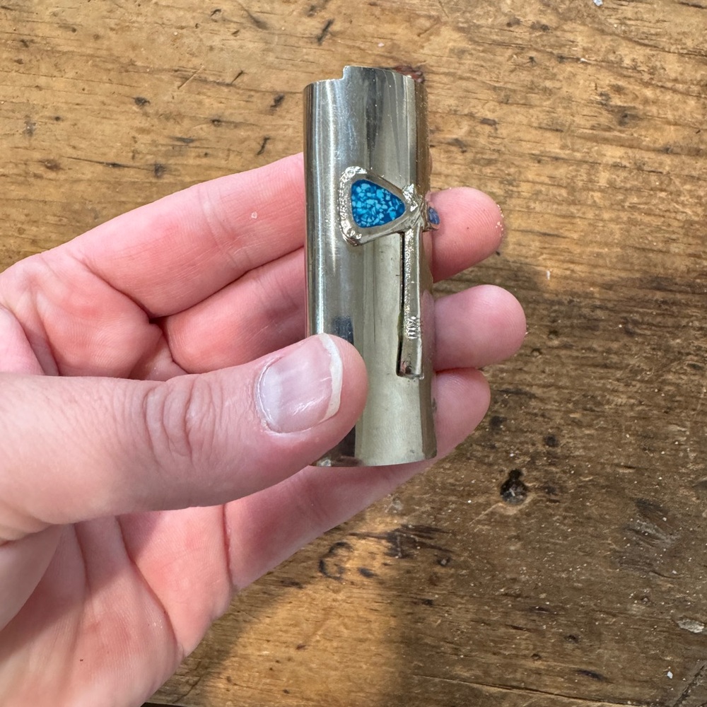 Silver vintage 1970s lighter cover featuring ax detail with turquoise